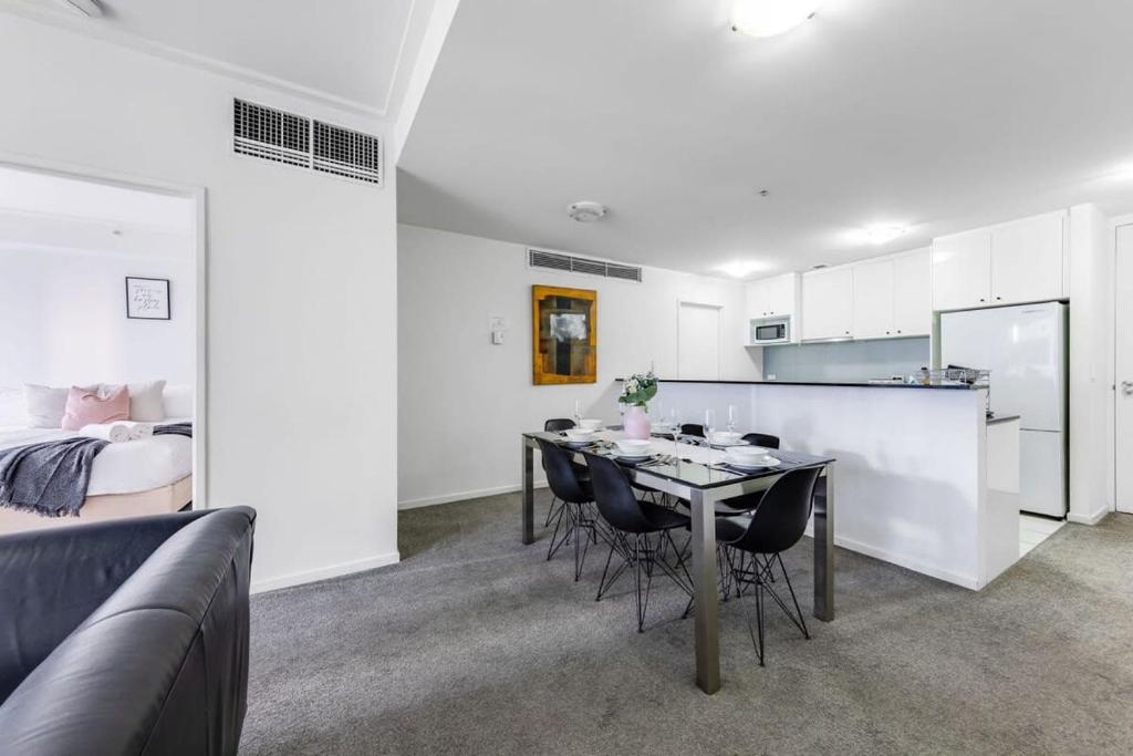 a living room with a table and a bedroom at A Comfy 2BR Apt Right Next to Darling Harbour in Sydney