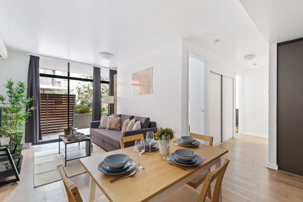 a dining room and living room with a table and chairs at A Spacious 2BR Apt with a Courtyard & FREE Parking in Melbourne