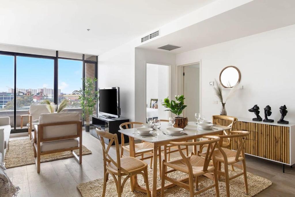 een eetkamer en een woonkamer met een tafel en stoelen bij A Lux 2BR Apt Next to Melbourne Uni FREE Parking in Melbourne