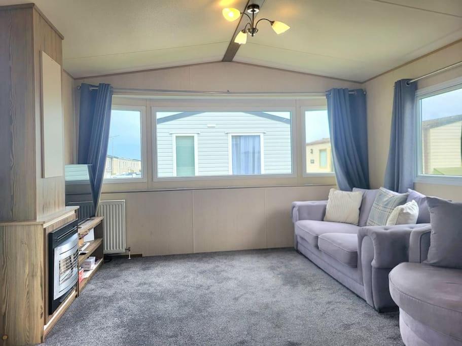 a living room with a couch and a window at Three bedroom holiday home in Whitstable