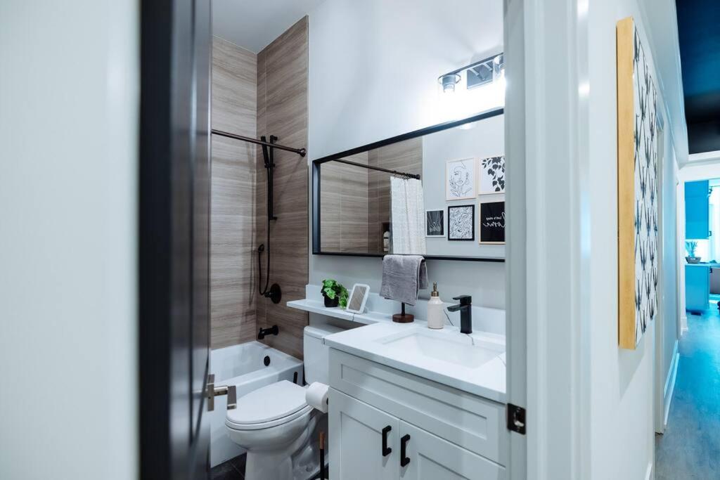 a bathroom with a toilet and a sink and a mirror at The Brown House - A luxurious UChicago Campus stay in Chicago