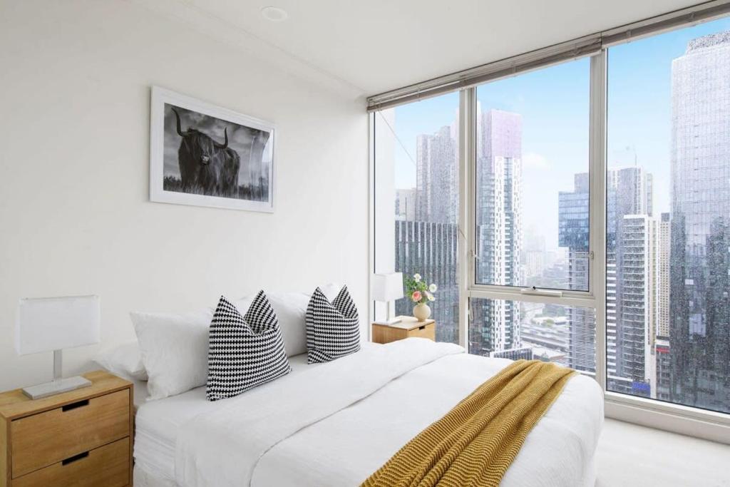 Comfy & Stylish 2BR Apt Next to Crown City Views في ملبورن: غرفة نوم بسرير ابيض ونافذة كبيرة