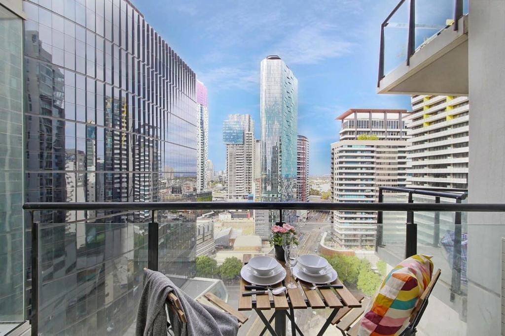 a balcony with a table and a view of a city at A Stylish 2BR Apt Next to Crown with FREE Parking in Melbourne