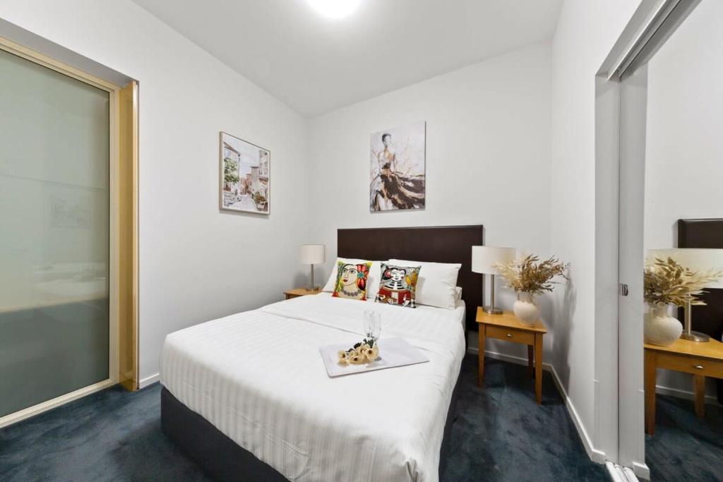 a bedroom with a white bed with a tray on it at A Chic Apartment on Bourke St Near Chinatown in Melbourne