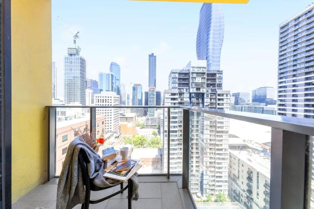 Elle comprend un balcon offrant une vue sur les toits de la ville. dans l'établissement A Chic 2BR Apt City Views Near Southern Cross, à Melbourne