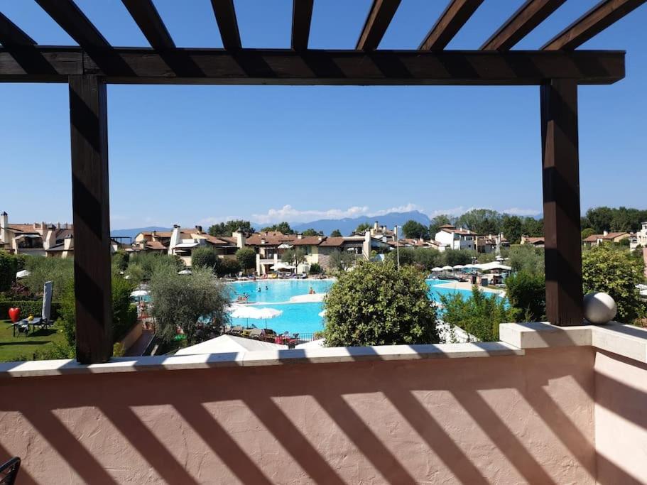 een balkon met uitzicht op het zwembad van een resort bij Lagosuite in Peschiera del Garda