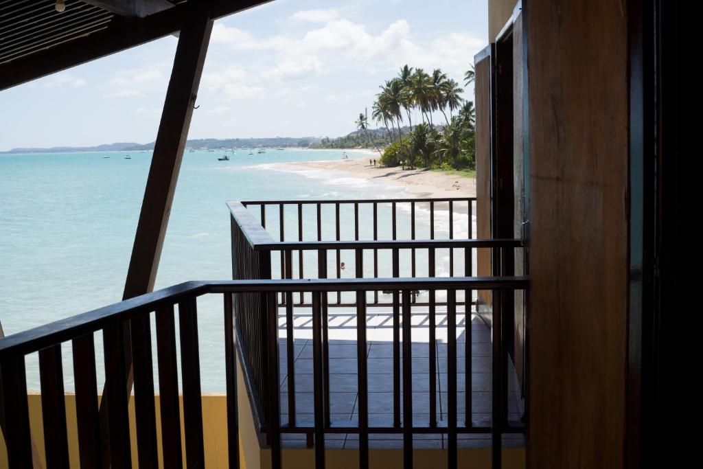 uma varanda com vista para a praia e para o oceano em Pousada Doutora Lindalva em Maragogi