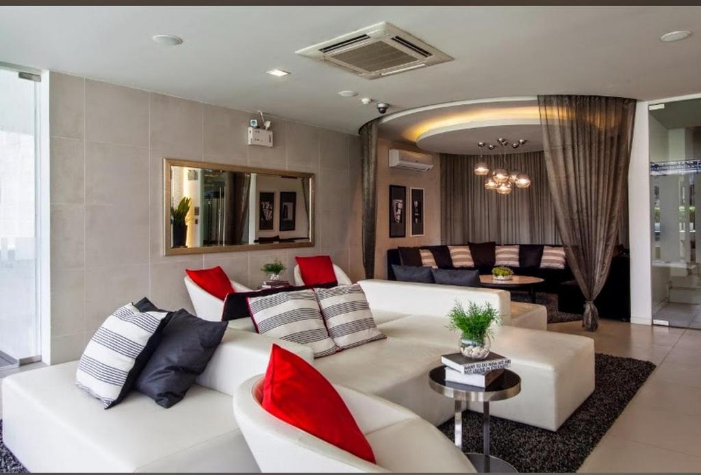 a living room with a white couch and red pillows at LIV@5 Condominium in Bangkok