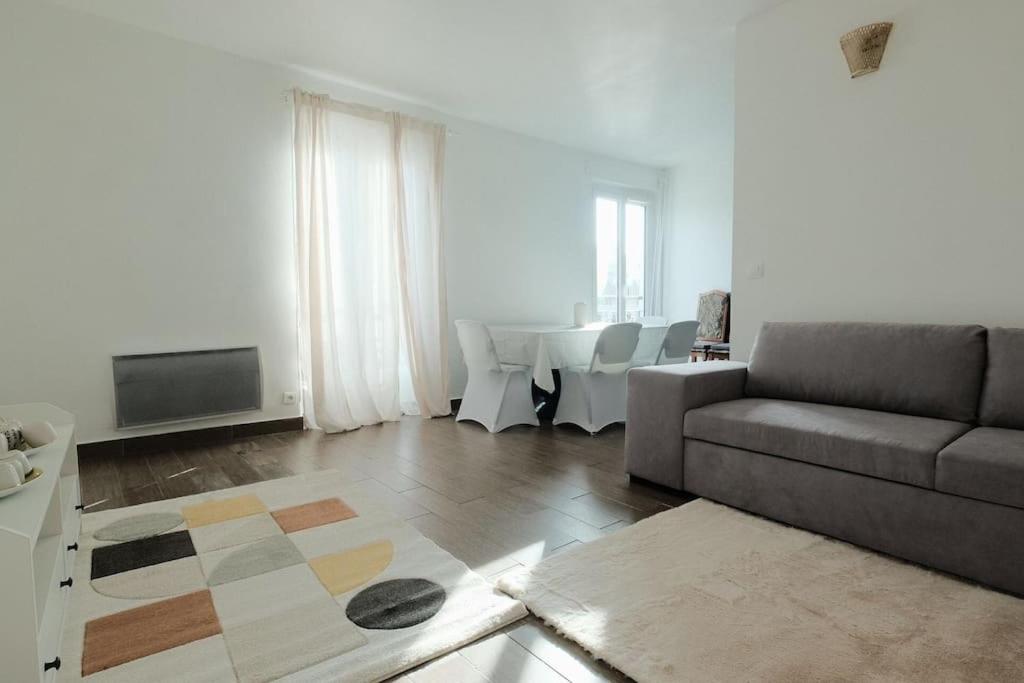 ein Wohnzimmer mit einem Sofa und einem Tisch in der Unterkunft Le Pinky Bird - Maisons Alfort in Maisons-Alfort