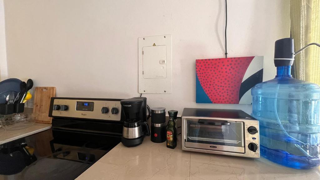 a kitchen counter with a microwave and a bottle of water at Amplio y moderno apartamento de 1 habitación in Tegucigalpa