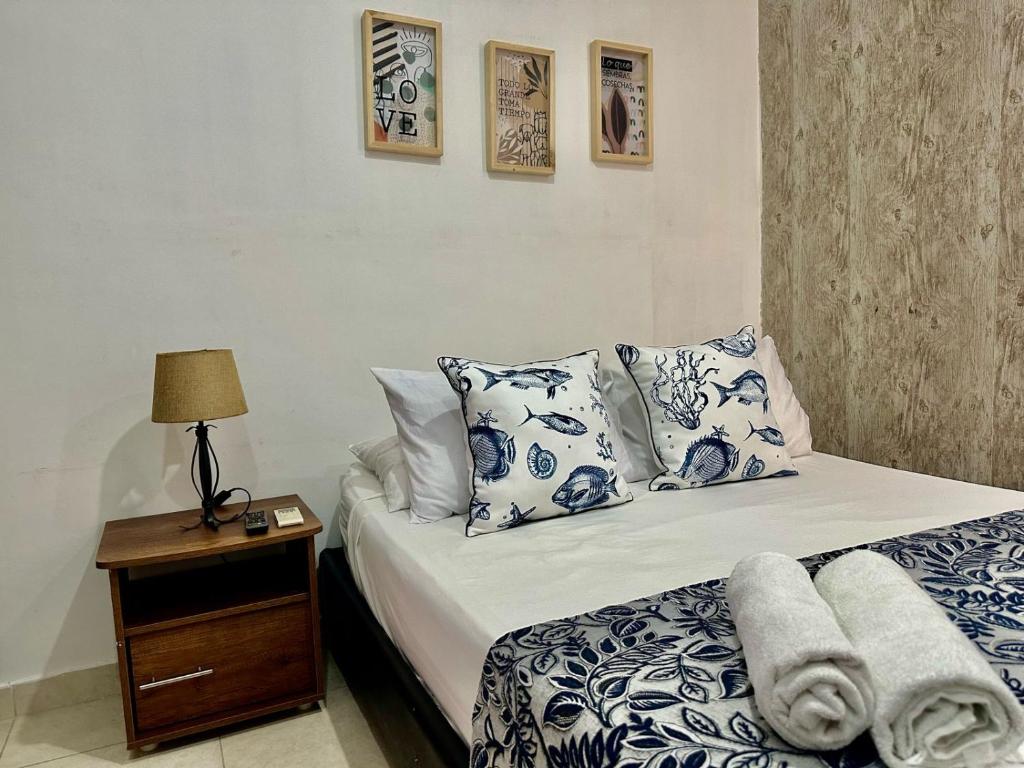 Schlafzimmer mit einem Bett mit blauen und weißen Kissen in der Unterkunft Hotel Casa Centro Historico De Cartagena Colombia in Cartagena de Indias