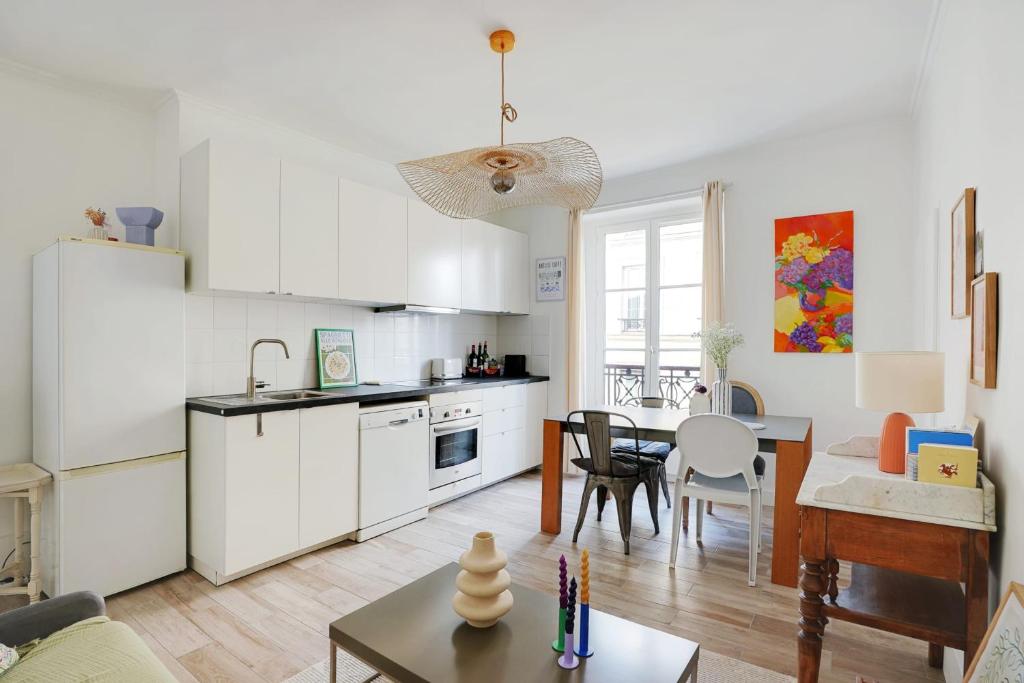 a kitchen and a living room with a table at OBERKAMPF - BASTILLE Charming apartment in Paris
