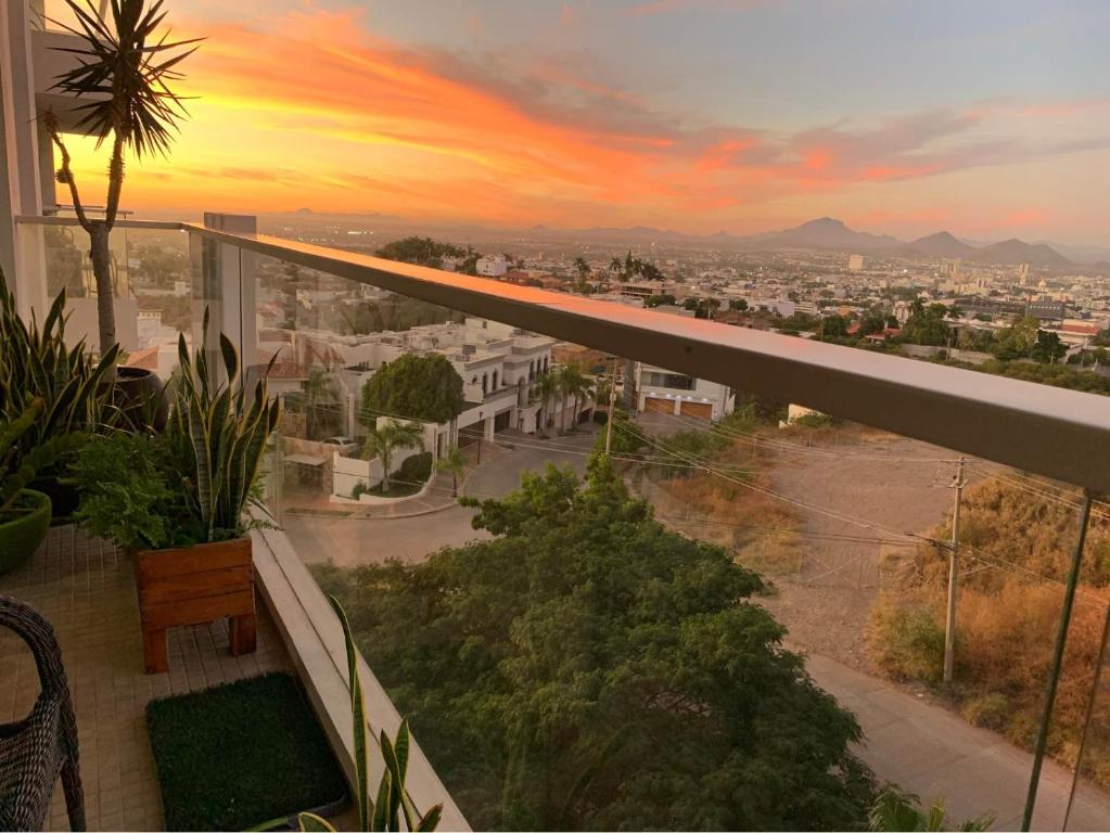 a balcony with a view of a city at sunset at Depa Centro Culiacán in Humaya