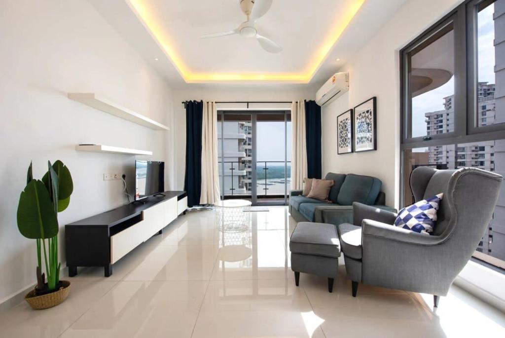 een woonkamer met een bank en een tv bij Comfy 3BR Apt in Danga Bay FREE Parking Sea View in Johor Bahru