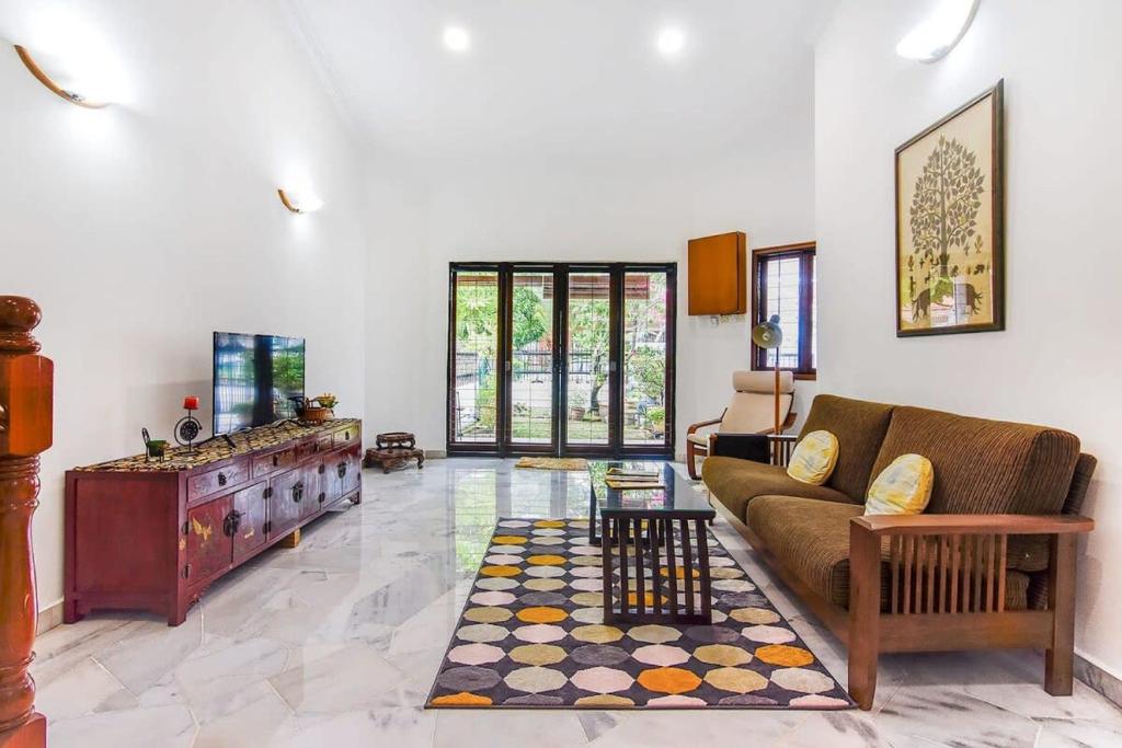 een woonkamer met een bank en een tafel bij A Stylish & Spacious 4BR Home for Family Getaways in Kuala Lumpur