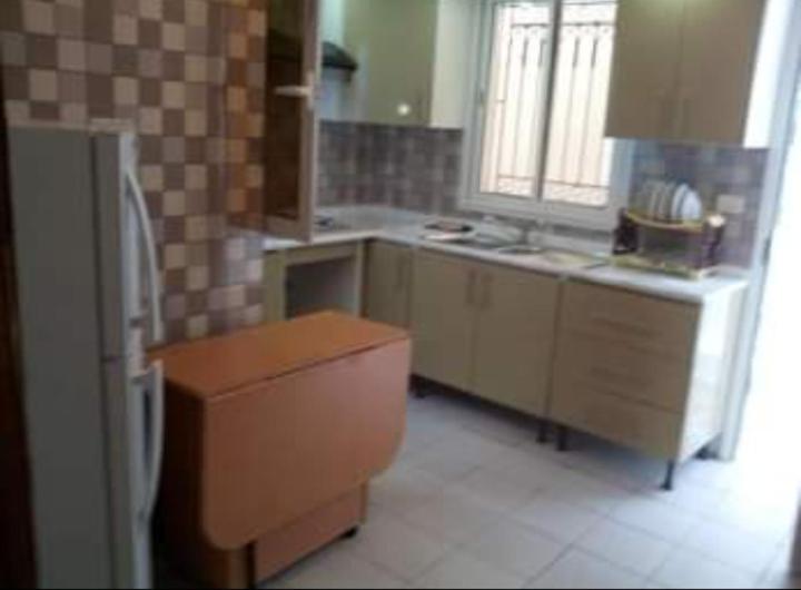 eine Küche mit einem Kühlschrank und einem Tisch darin in der Unterkunft Maison à hergla in Sousse