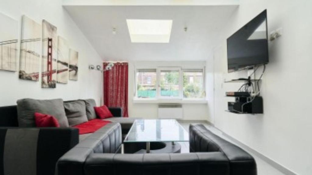 a living room with a couch and a table at Spacieuse maison avec chambres et salle de bain privées en colocation à 10 min de Lille in Lille