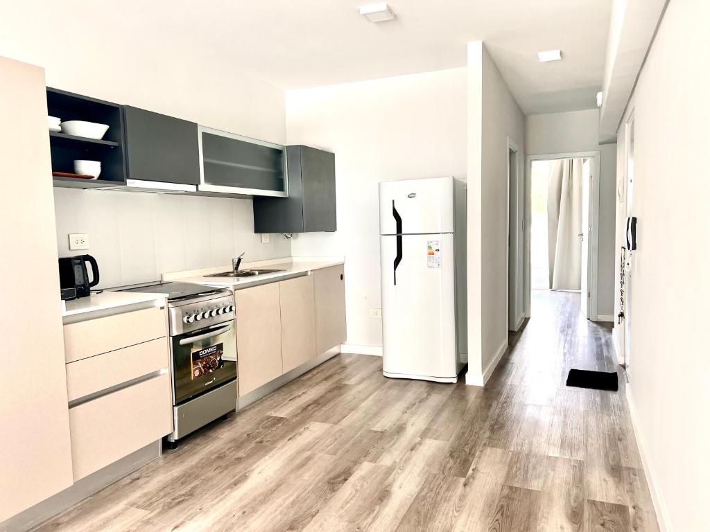 cocina con electrodomésticos blancos y nevera en Depto con vistas, en San Nicolás de los Arroyos