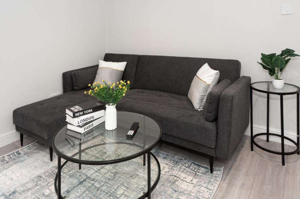 uma sala de estar com um sofá e uma mesa com livros em Modern 1BR Haven Central Croydon em Croydon