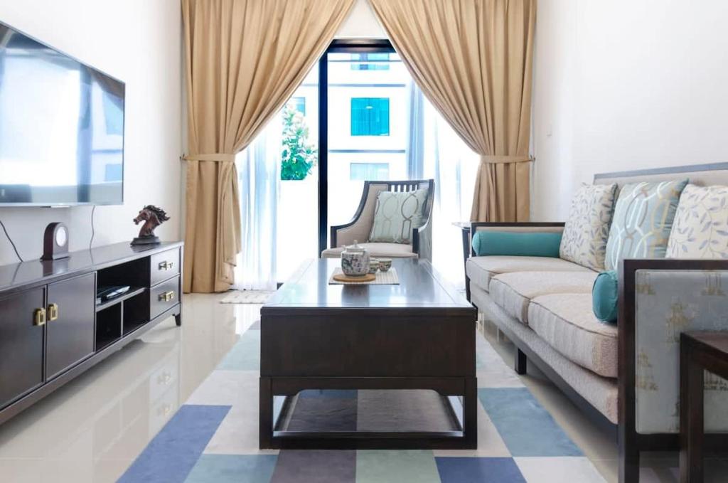 een woonkamer met een bank en een tv bij A Comfy & Cozy Suasana Suites in Johor Bahru in Johor Bahru
