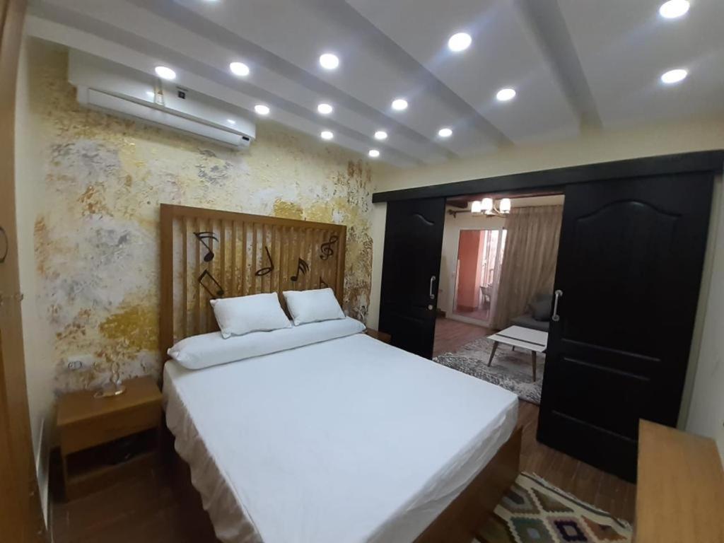 a bedroom with a large white bed in a room at بورتو مارينا الساحل الشمالي in El Alamein