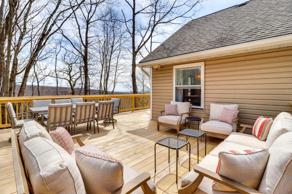 una terraza con sillas y sofás en un porche en Family-Friendly Albrightsville Cabin Deck and Views, en Albrightsville