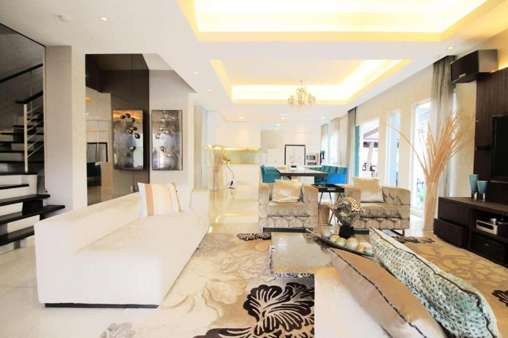 een woonkamer met een bank en een tafel bij A Spacious & Lux 4BR House with Gazebo in Cheras