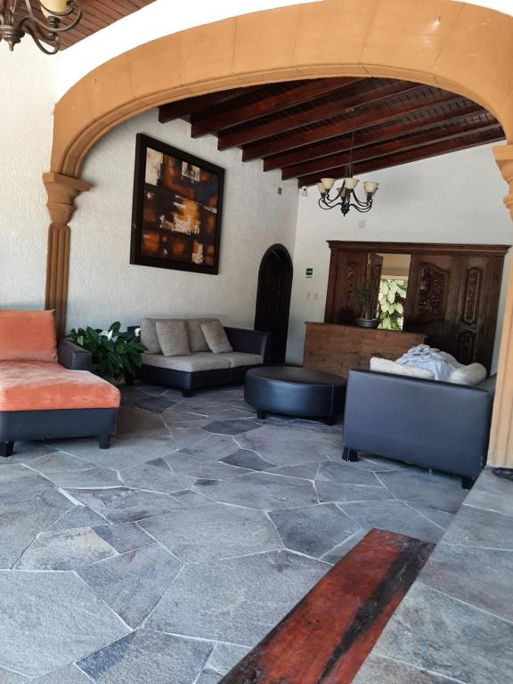 - un salon avec des canapés et un sol en pierre dans l'établissement Quinta Boutique Zana, à Cuernavaca