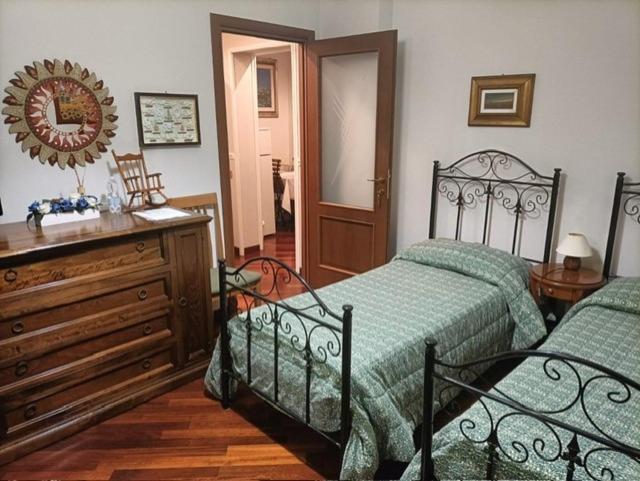 a bedroom with two beds and a dresser and a mirror at Dolce Risveglio vicino Milano in Trezzano sul Naviglio