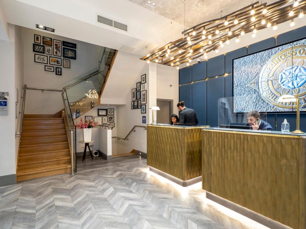eine Lobby eines Restaurants mit einer Bar und einer Treppe in der Unterkunft Hotel Indigo London Hyde Park Paddington, an IHG Hotel in London