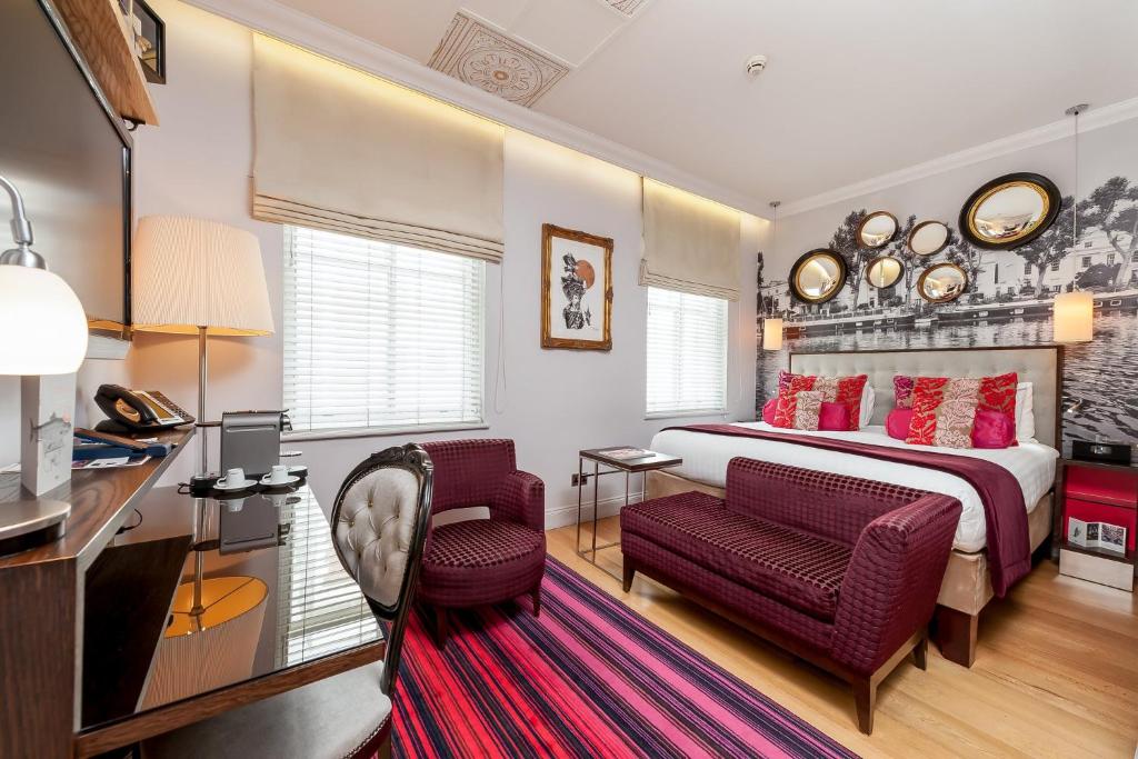 - une chambre avec un lit, un bureau et des chaises dans l'établissement Hotel Indigo London Hyde Park Paddington, an IHG Hotel, à Londres