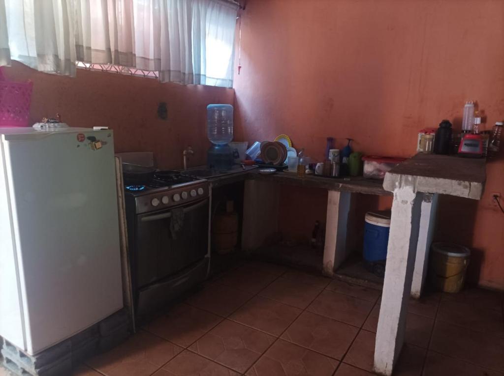 マナグアにあるHospedaje Marlenisのキッチン(コンロ、白い冷蔵庫付)