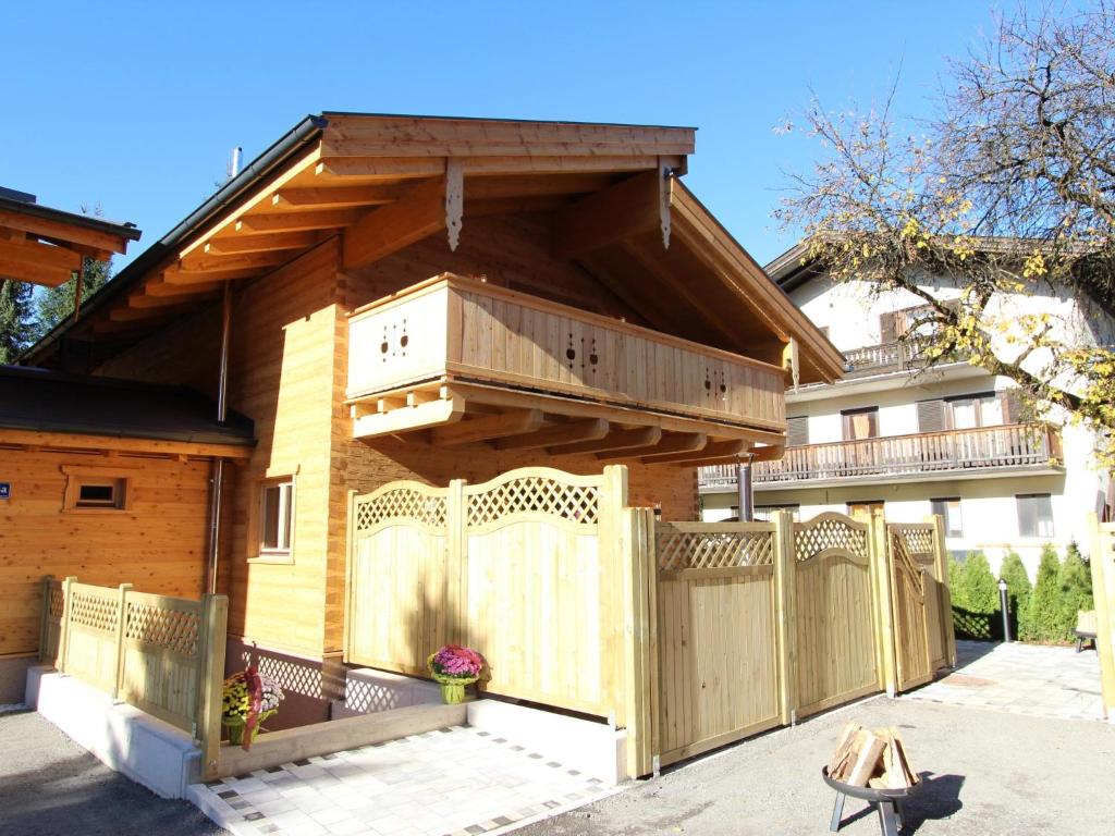 une maison avec une clôture en bois et un balcon dans l'établissement Luxury Lodge Kaprun Ost A, à Kaprun