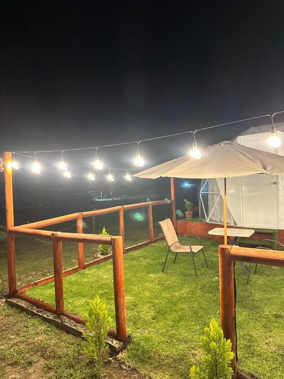 a patio with an umbrella and a table and a chair at Glamping El Encanto in Zapopan