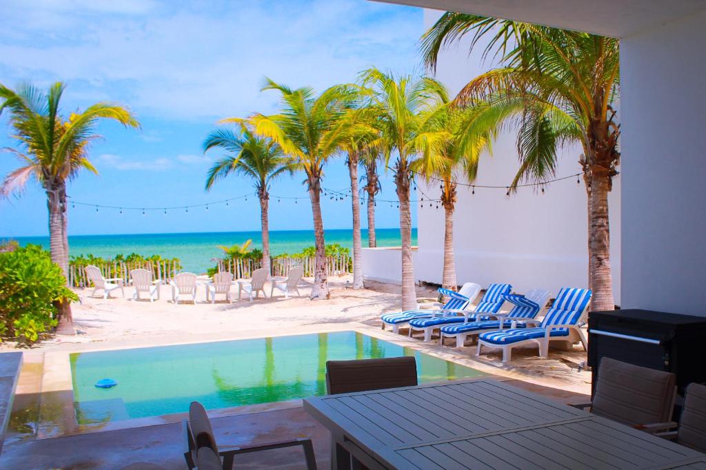 a pool with chairs and palm trees on the beach at Patmos ocean view 3 bedroom house in San Benito