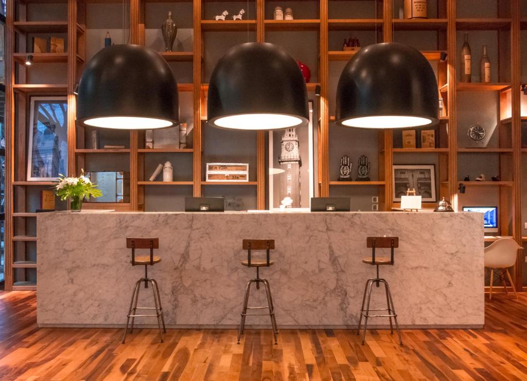 a lobby with a concrete counter and black pendant lights at CasaSur Palermo Hotel in Buenos Aires