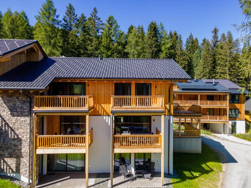 une grande maison en bois avec balcon et arbres dans l'établissement Silas Mountain Chalet, à Turracher Höhe