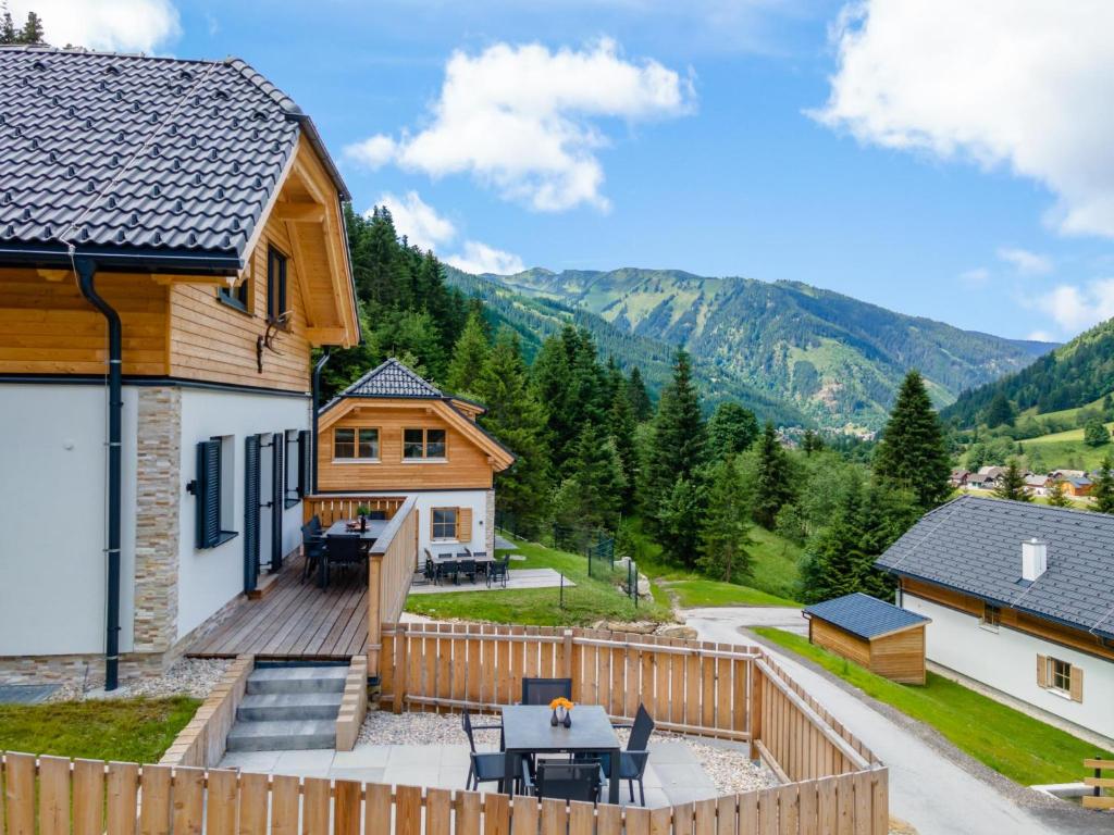 une maison avec une terrasse offrant une vue sur les montagnes dans l'établissement Edelweiss Lodge, à Donnersbachwald