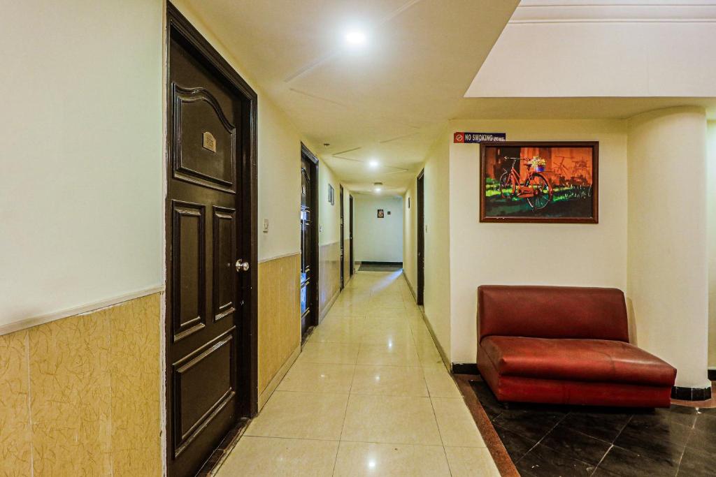 a hallway in a hospital with a chair and a door at Townhouse Hotel Taksonz in Ludhiana