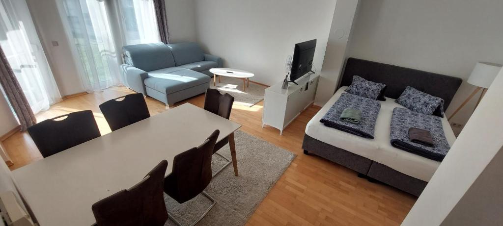 uma sala de estar com uma cama, uma mesa e um sofá em Ferienwohnung Dado em Eisenstadt