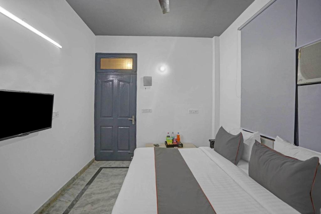 a room with a bed and a tv and a door at OYO Flagship Premium Villa in New Delhi