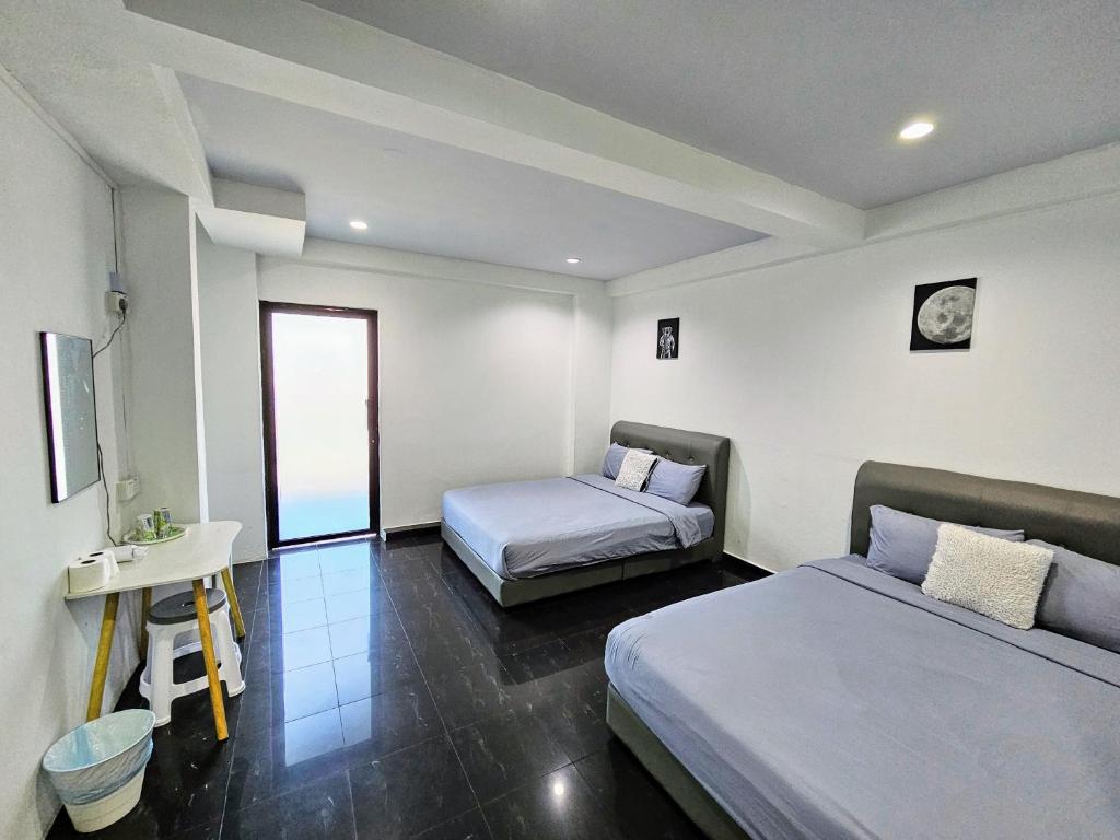 a bedroom with two beds and a table and a desk at 184 GURNEY DRIVE PENANG in George Town