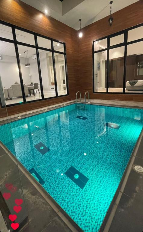 - une grande piscine d'eau bleue dans une maison dans l'établissement REST IN 2, à Unayzah