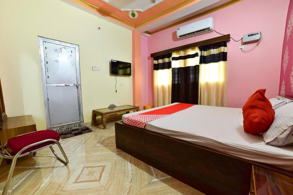 um quarto com uma cama com almofadas vermelhas em OYO Flagship Ashoka Guest House em Bihta