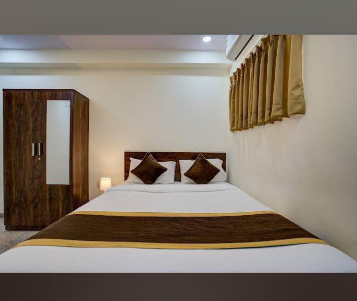 Una cama o camas en una habitación de Hotel Madiwala Grand