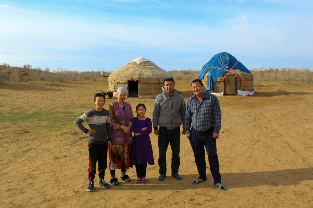 uma família posa para uma foto em frente a uma tenda em Yurt Stay Family Khansar em Nurota