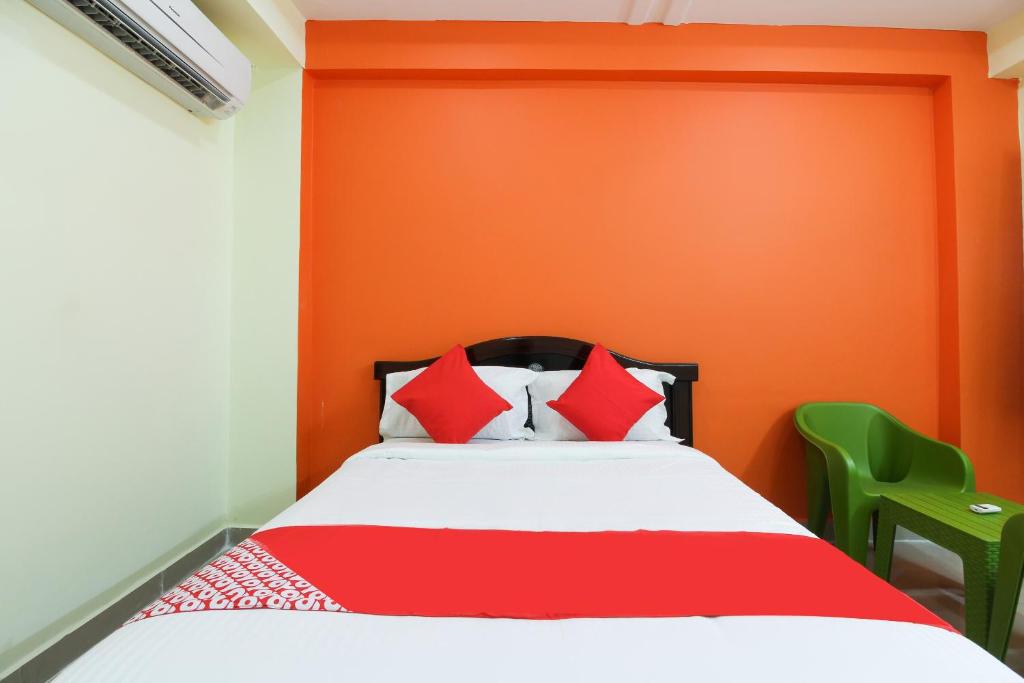 a bedroom with orange walls and a bed with red pillows at Flagship S V Residency in Lingampalli