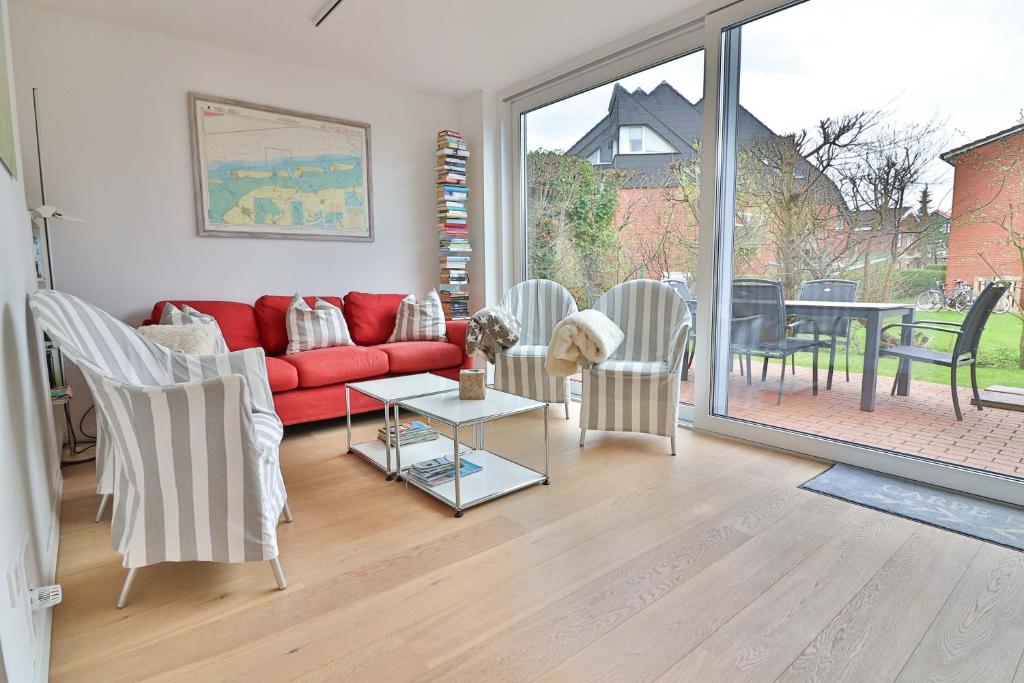 a living room with a red couch and a table at Orange Hygge Haus in Langeoog