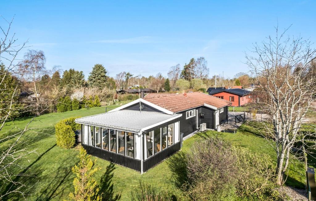 uma imagem de uma casa negra num campo verde em Amazing Home In Hjby With Wifi em Højby