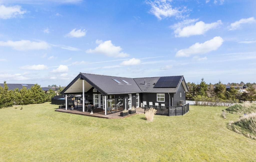 a house with a black roof on a grass field at Gorgeous Home In Jerup With Sauna in Jerup